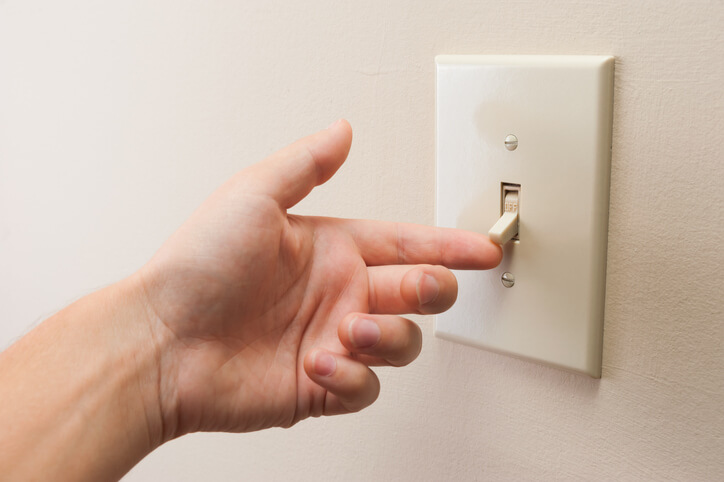 hand flipping light switch to on